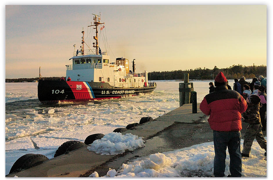 The US Coast Guard ship Biscayne Bay clearing the Beaver Island dock where spectacters cheer her freeing the channel into Paradise Bay